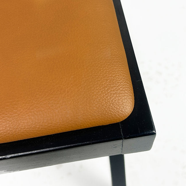 Leatherette seat with rounded wood corners.
