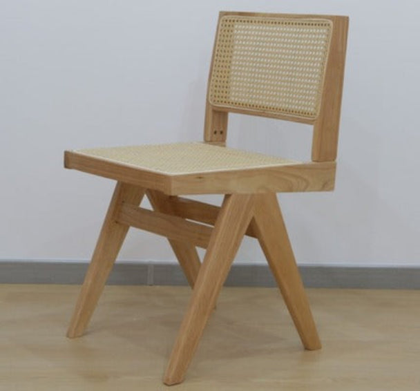Natural finish dining chair with rattan back and padded neutral seat.

