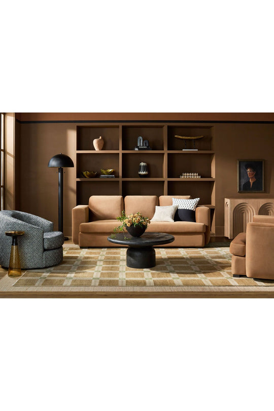 Modern living room with tan velvet sofa, built-in shelving, and geometric decor - curated modern furniture from Room to Bloom INC.